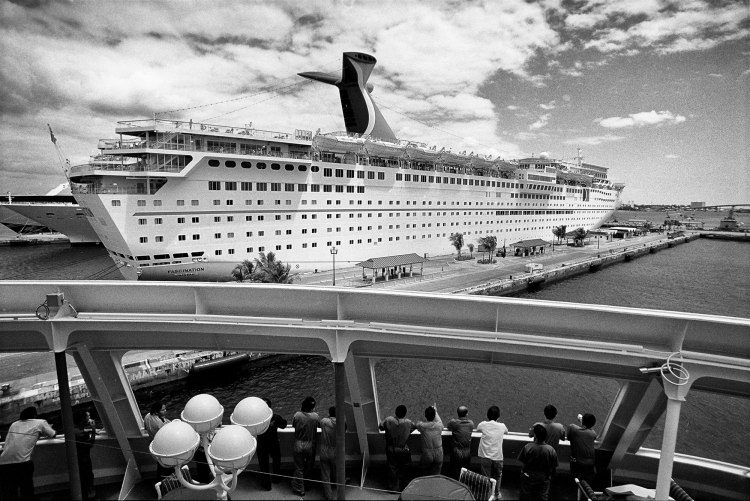 Transatlantiklerin limana yanaşmaları uzun ve zahmetli bir operasyondur. Yavaş ilerleyen bu süreç, işi olmayan personel için çoğunlukla keyifli bir seyir aktivitesidir. Moladaki Filipinli güverte işçileri, Sovereign of the Seas transatlantiğinin Nassau limanına yanaşmasını izliyorlar. Sovereign of the Seas, Nassau, Bahamas, 2004 © Mehmet İlbaysözü